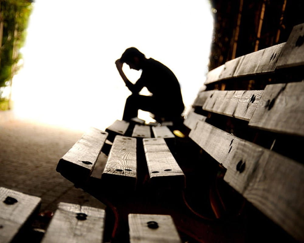 Depressed man sitting on a bench