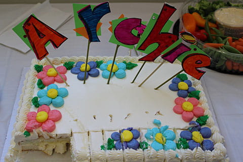 A frosted white cake that has Archie on it. 
