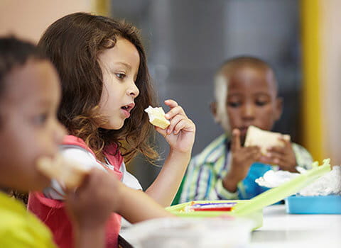 Kids eating sandwiches. 