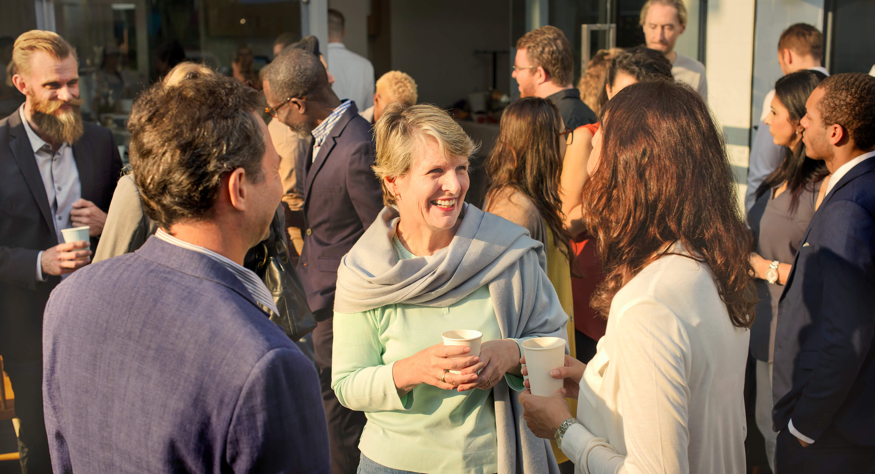A group of adults mixing at a community meeting event.