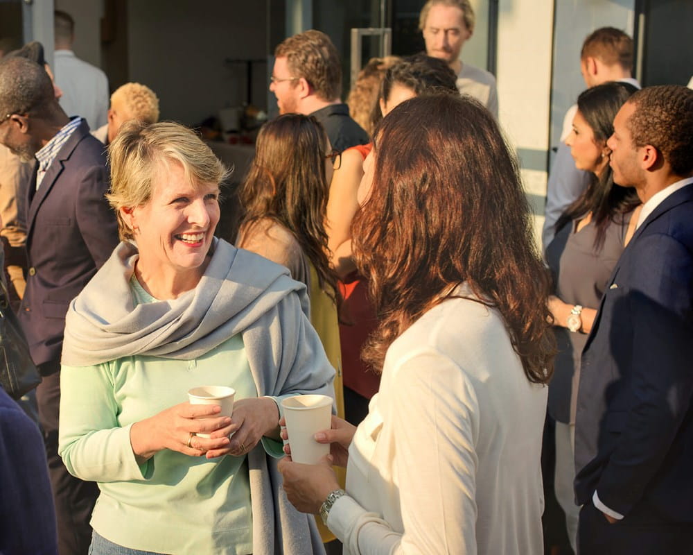 A group of adults mixing at a community meeting event.