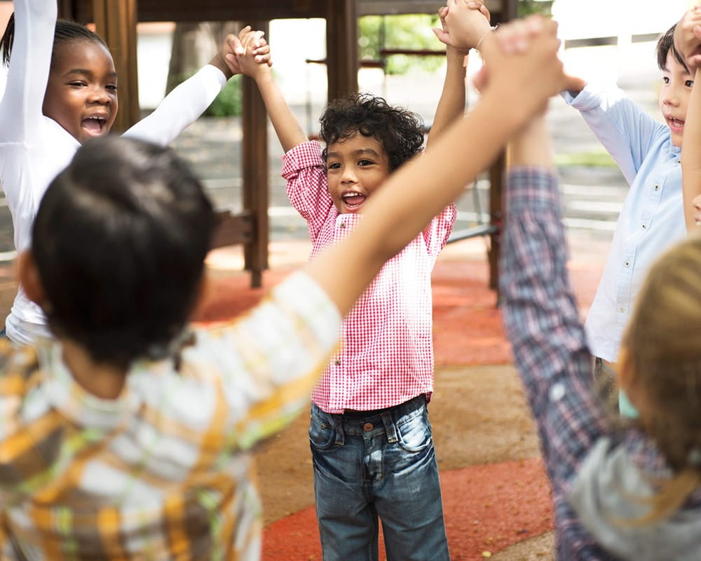 Kindergarten students holding hands in a circle.