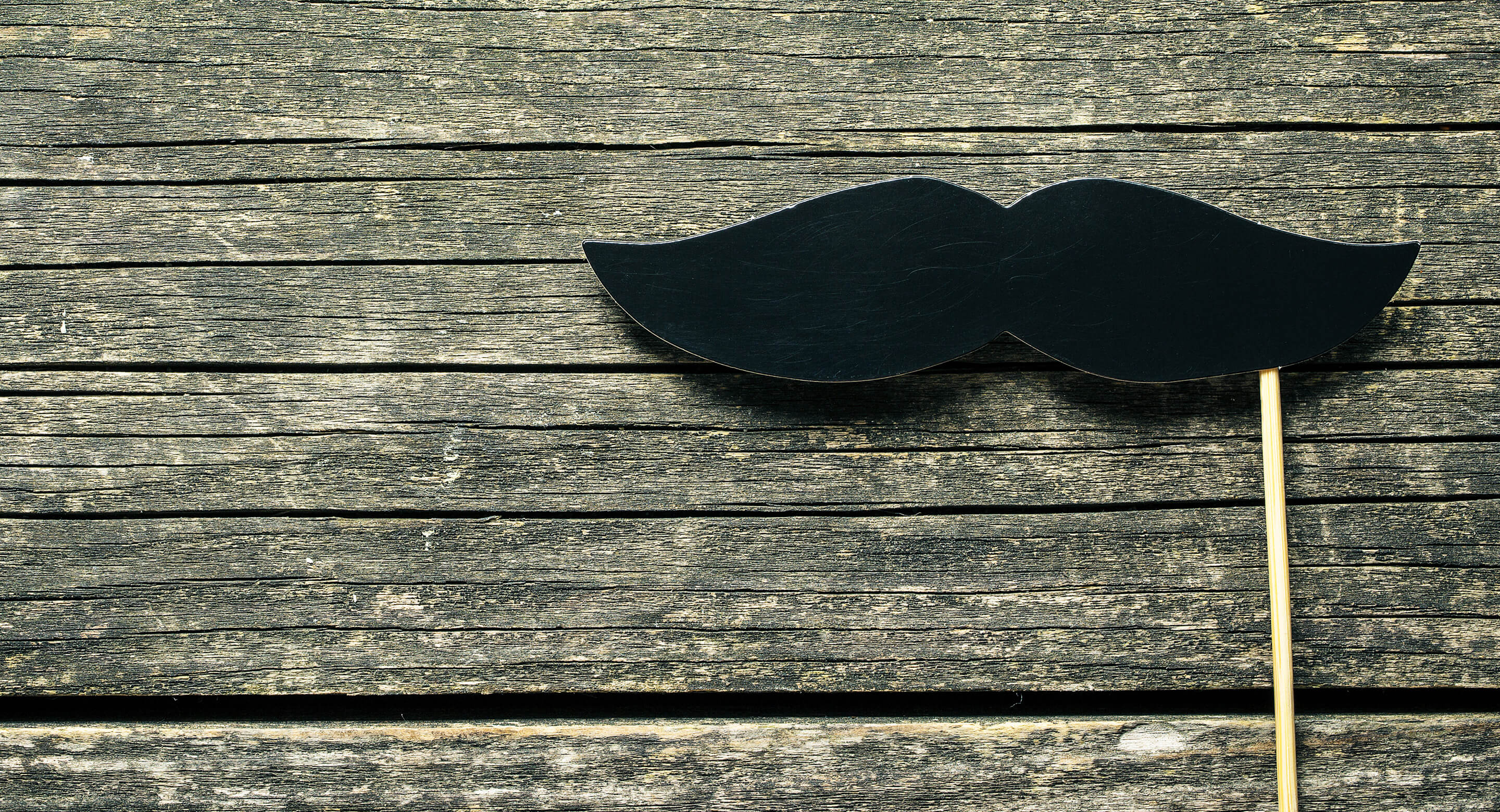 Fake moustache on wood background