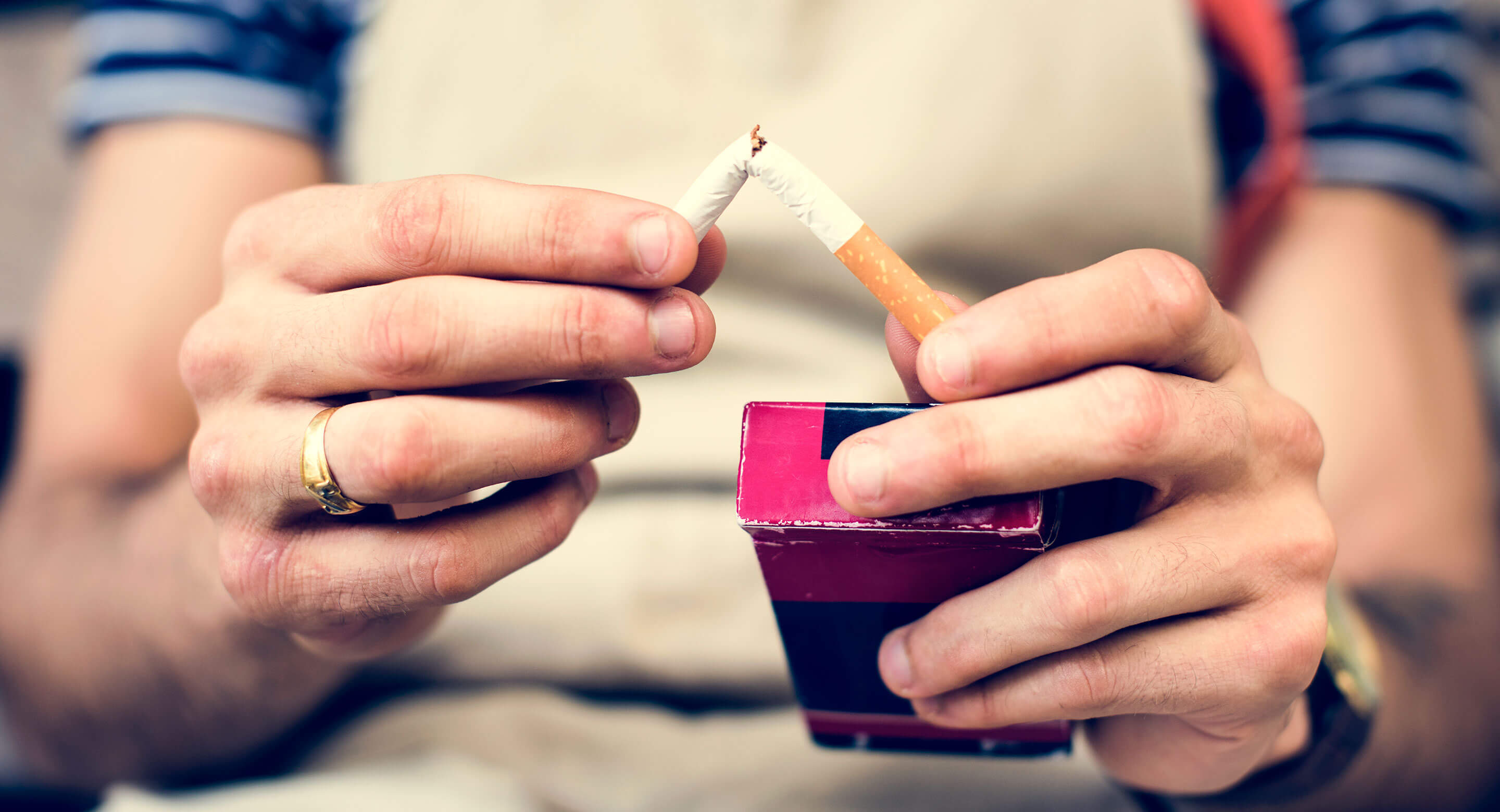 Photo of someone snapping a cigarette in half.