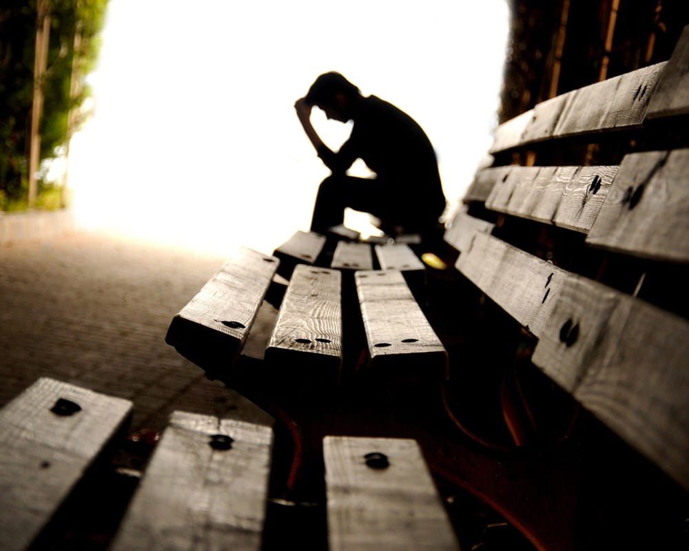 Person sitting along looking like they are in distress