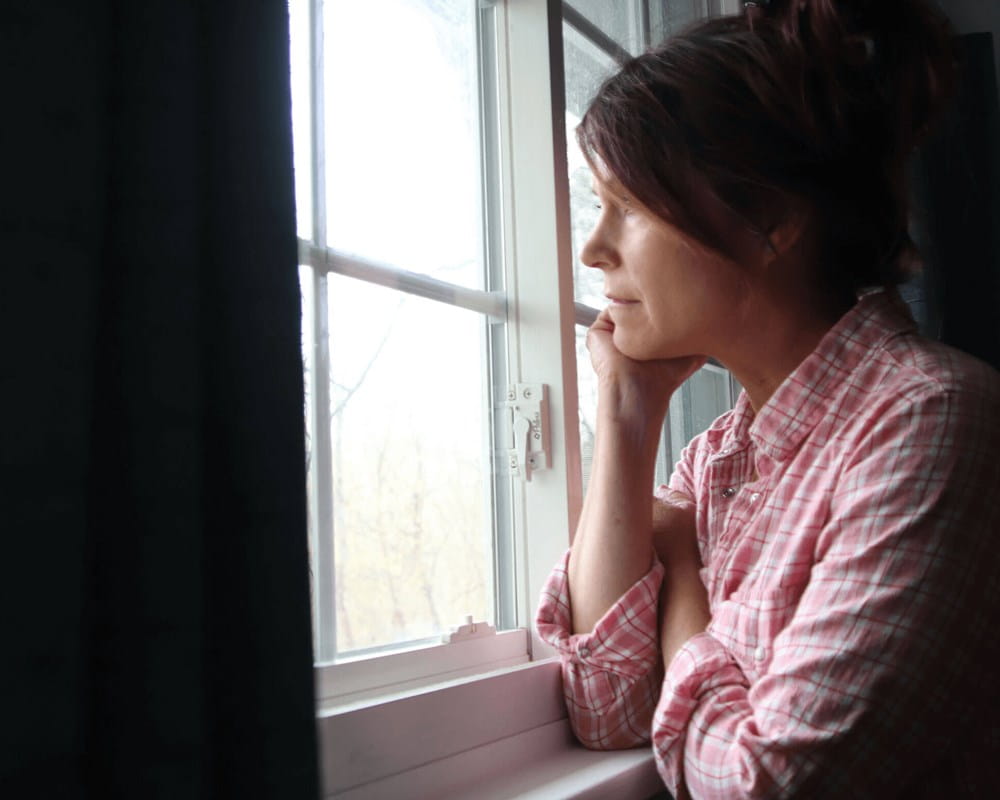 Sad woman looking out window