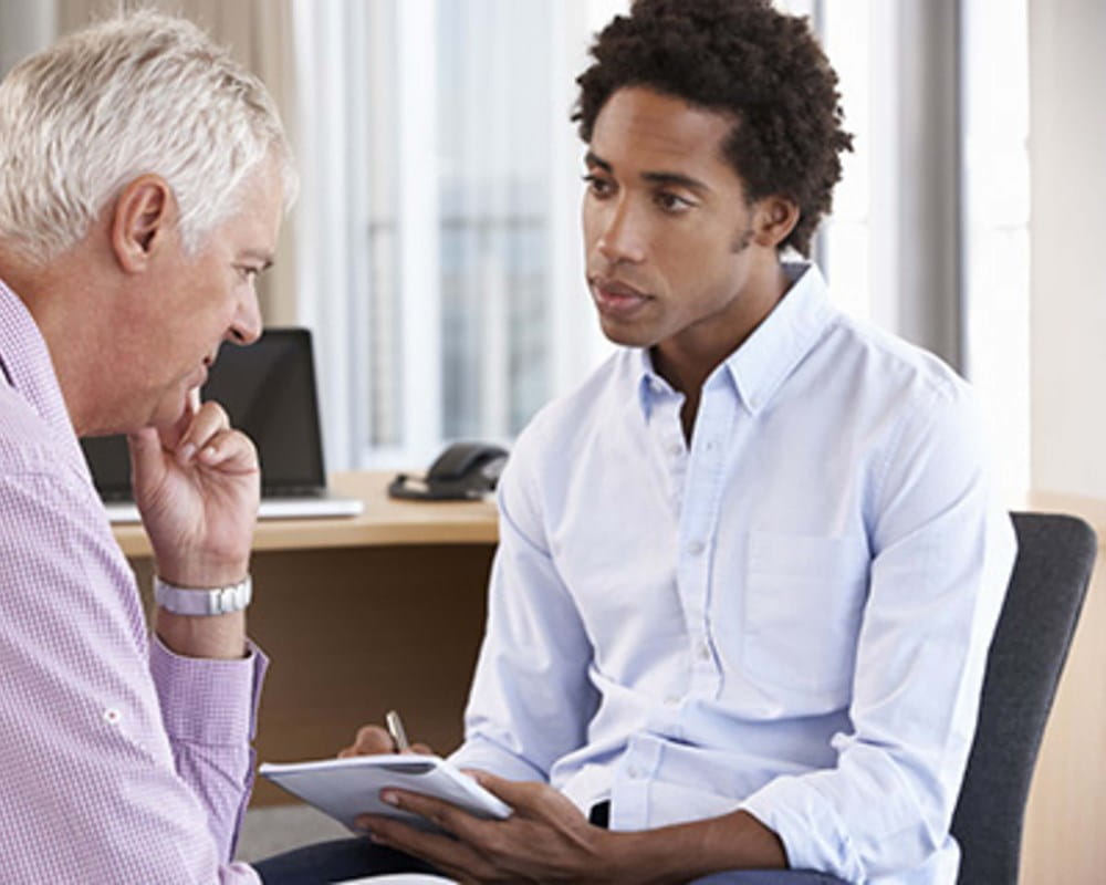 Older man talking to young doctor