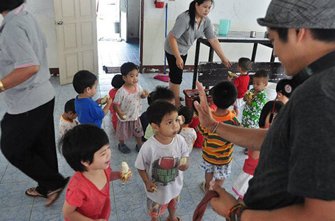 A man visiting an Orphanage filled with young children in Thailand.