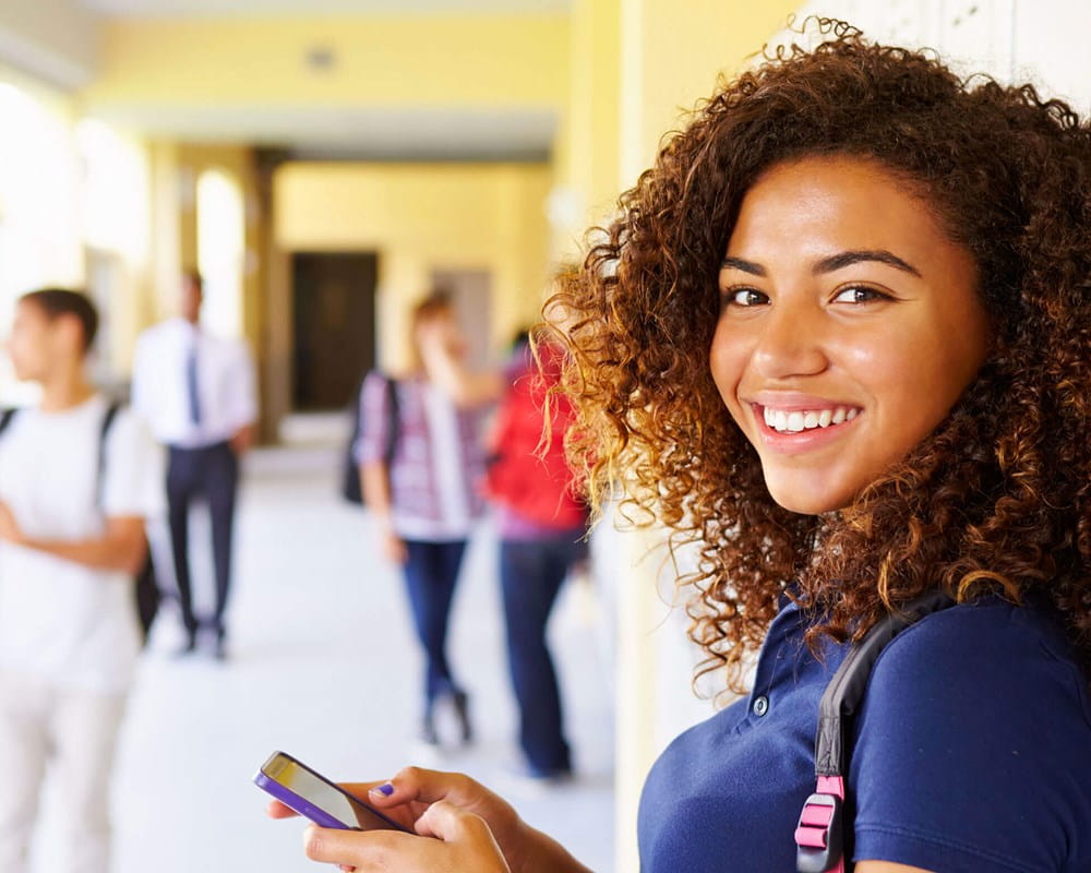 Teenage girl standing in school hallway
