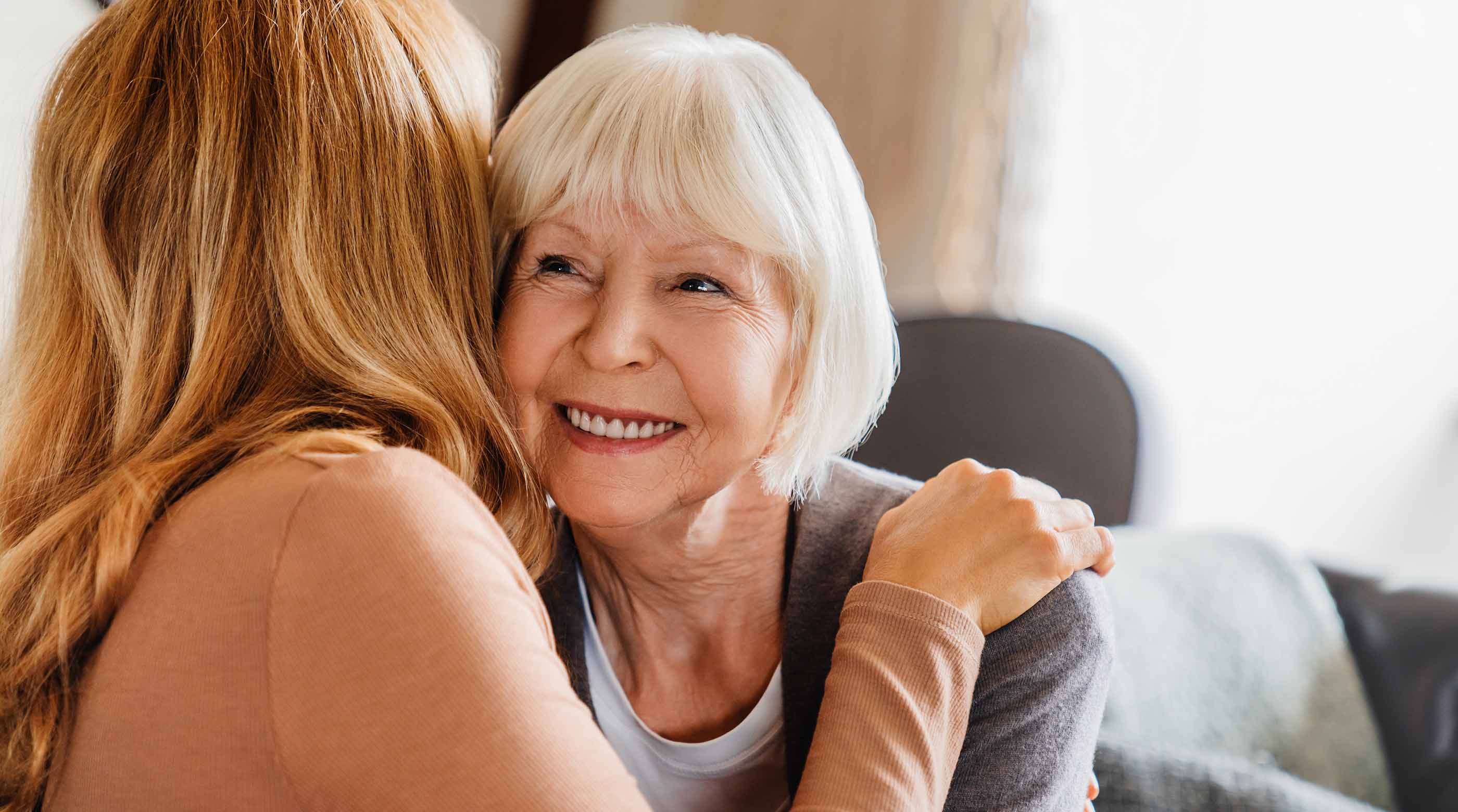 An older woman hugging a younger woman