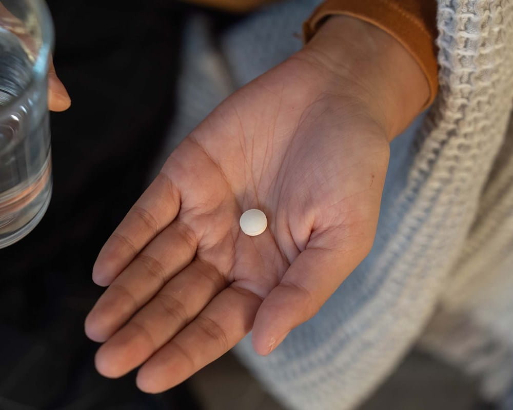 A person prepares to take a pill