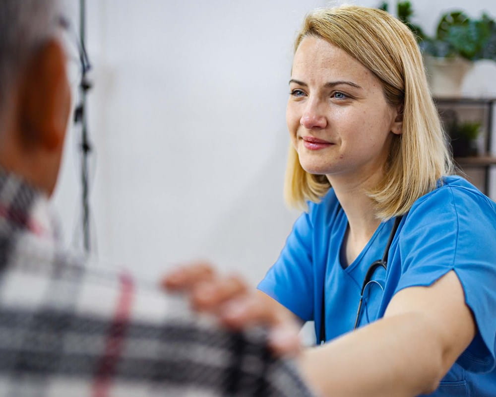 Clinician comforts a patient with their hand on the patient's shoulder
