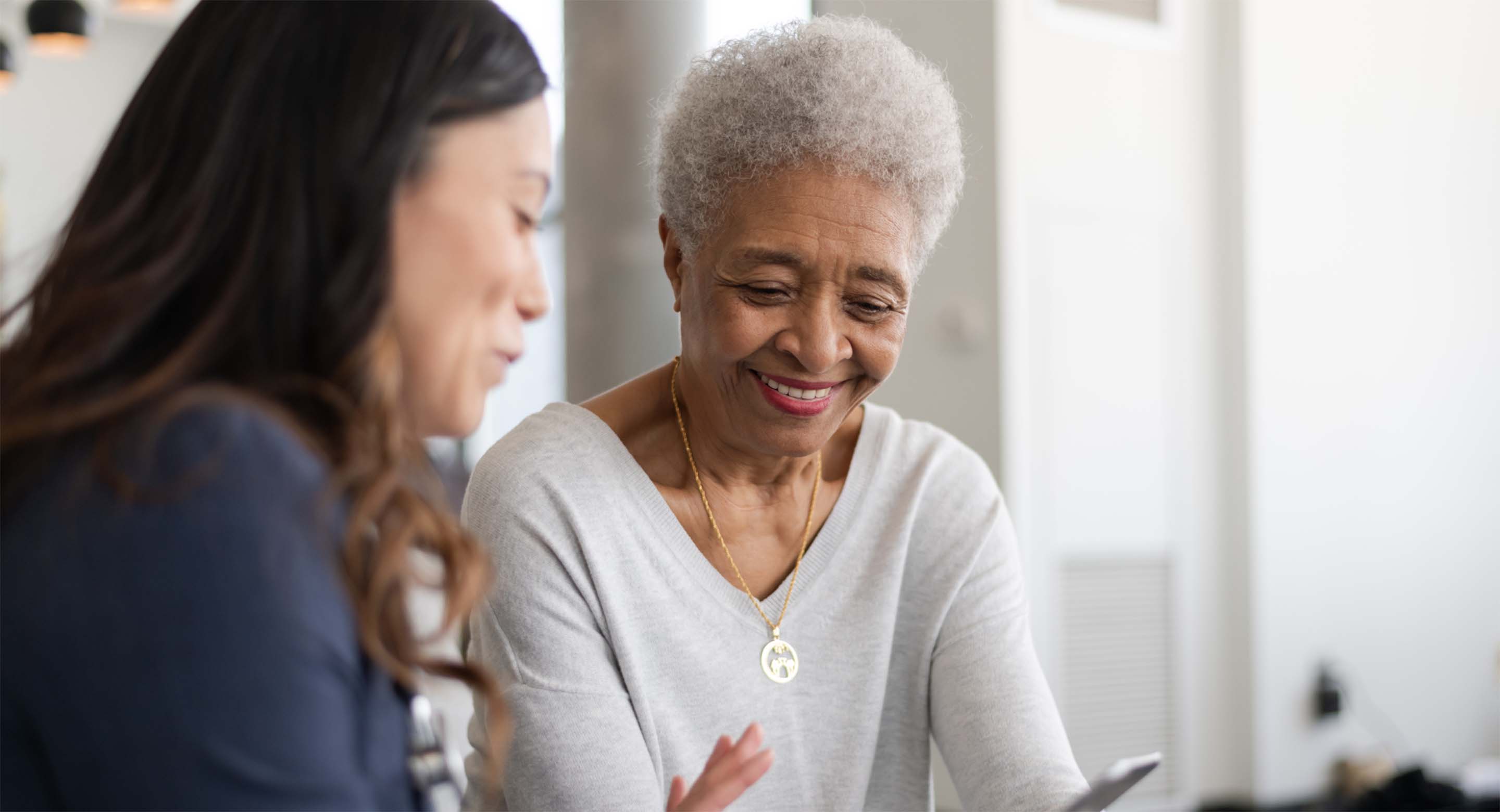 two women looking at a phone or tablet