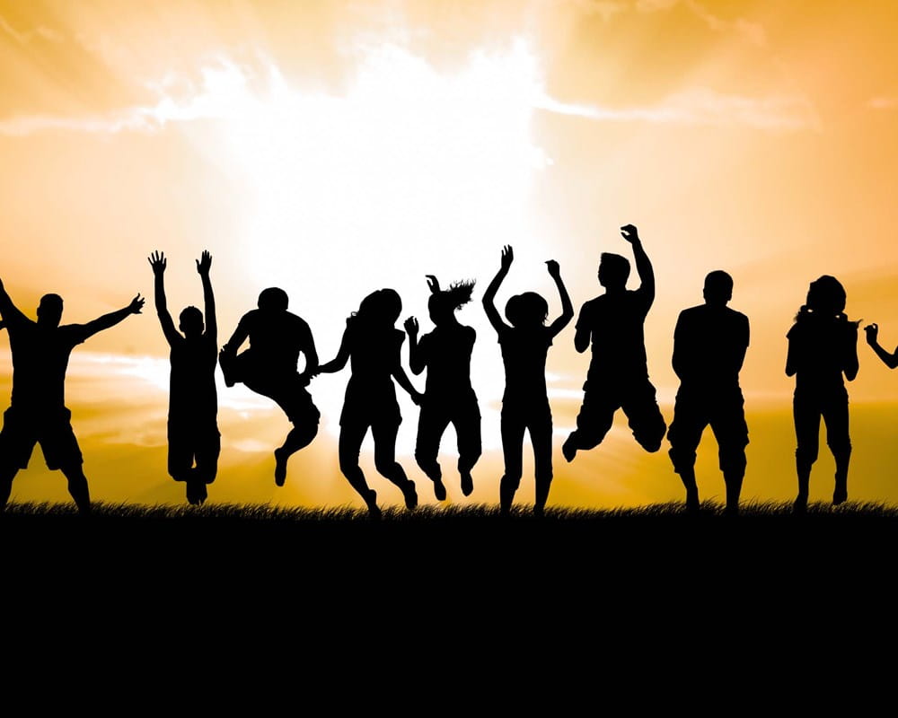 Image of silhouettes of people holding hands in a field